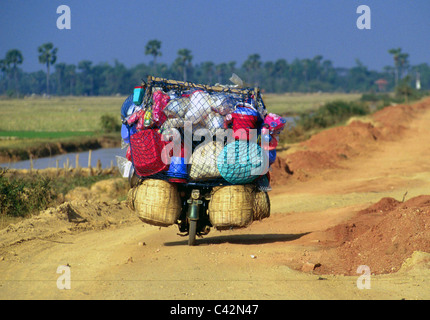 Voyageant tinker le vélo avec ménage on country road, district de Takeo, au Cambodge Banque D'Images