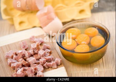 Matières d'oeuf dans un bol en verre et de saucisse hachée Banque D'Images