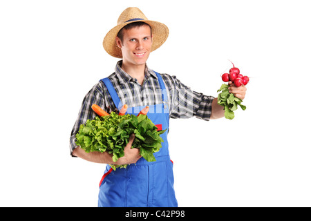 Un jeune agriculteur holding vegetables Banque D'Images