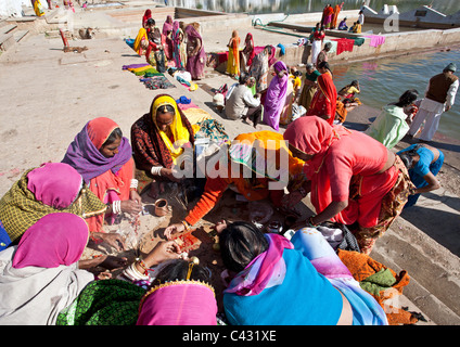 Les femmes indiennes de faire un rituel à l'épargne (puja). Lac Pushkar. Le Rajasthan. L'Inde Banque D'Images