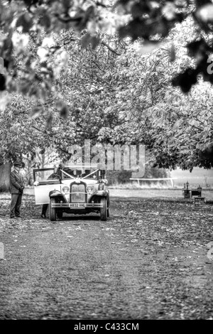 Rolls Royce voiture mariage la prestation promise de réception à l'ancienne maison de campagne bordée d'arbres Banque D'Images