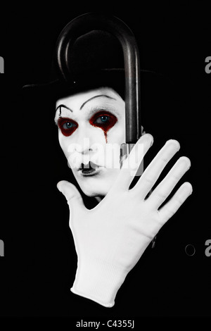 Portrait d'une terrible mime tenant un bâton de marche à la main Banque D'Images