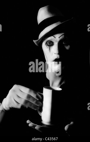 Portrait de clown mime terrible holding white cup Banque D'Images