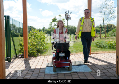 Une jeune fille handicapée subit l'enseignement dans l'utilisation sécuritaire d'un scooter de mobilité au Centre for Disability Studies au Royaume-Uni. Banque D'Images