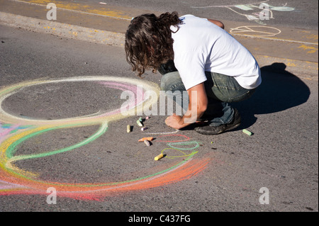 Un homme de couleur vive les craies d'art sur le trottoir de la rue Higgins pont à la deuxième Dimanche de l'événement dans les rues. Banque D'Images