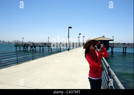 Fille asiatique avec l'appareil photo sur l'île Shelter la jetée de pêche dans la baie de San Diego Banque D'Images