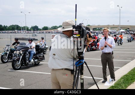 Rolling Thunder Motorcycle Rally TV reporter Washington DC / WASHINGTON, DC, États-Unis — Un journaliste de télévision diffuse un flux devant les coureurs qui partent pour le rallye annuel de motocyclettes Rolling Thunder dans le centre-ville de Washington DC le 29 mai 2011. Cette photo a été prise alors que les coureurs quittaient la zone de rassemblement dans le parking nord du Pentagone, où des milliers de vélos et de coureurs s'étaient rassemblés. Banque D'Images