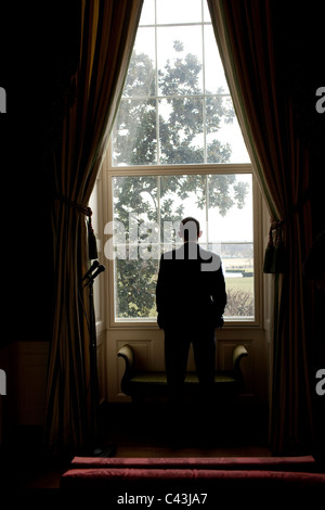 Le président américain Barack Obama regarde par la fenêtre de la Maison Blanche Banque D'Images