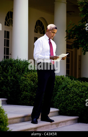Le président Barack Obama se lit un document à l'extérieur du bureau ovale sur les étapes menant à la Roseraie, le 20 mai 2009. Banque D'Images