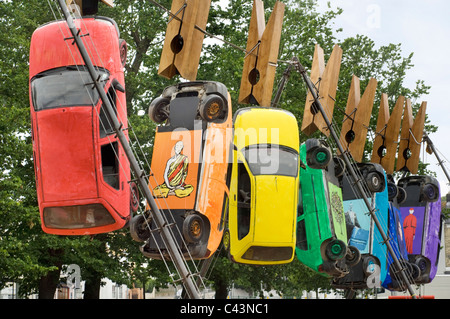 Sept voitures se suspendre à des pinces à linge géantes sur un fil à Brighton dans le cadre du Fringe Festival annuel d'art du théâtre de rue. Banque D'Images