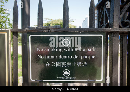 Un signe en anglais, espagnol et chinois à l'extérieur Parc McCarren à Brooklyn à New York informe les fumeurs de l'interdiction de fumer Banque D'Images