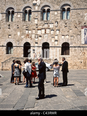 Groupe de femelles et mâles italiens habillés pour un désherbage en face du Palazzo del Podestà, Toscane, Italie Banque D'Images