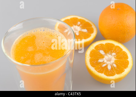 Verre de jus d'orange fraîchement pressé avec des fruits Banque D'Images