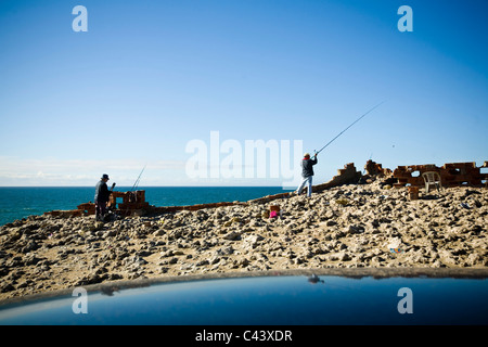 Deux pêcheurs de la pêche sur la côte du Portugal. Cette côte est fortement la décomposition des vagues de l'océan. Près de Cabo da Roca. Banque D'Images