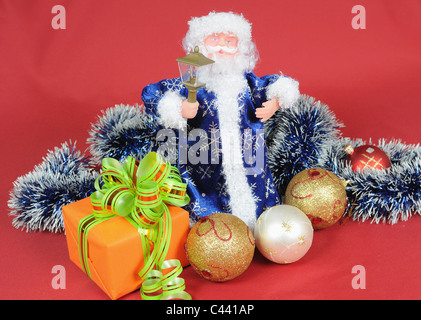 Père Noël jouet avec une décoration de Noël sur fond rouge Banque D'Images