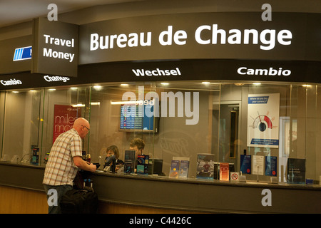 Un voyageur changer de l'argent au Bureau de change, North terminal, Gatwick Airport UK Banque D'Images