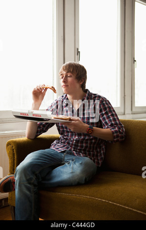 Un adolescent eating pizza livraison Banque D'Images