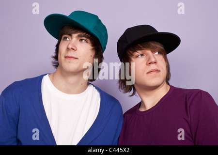 Deux jeunes garçons portant des casquettes de baseball à la suite, studio shot Banque D'Images