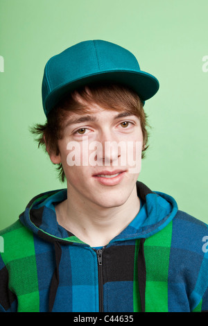 Un adolescent vêtu d'un sweat et casquette, portrait, studio shot Banque D'Images