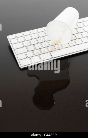Une tasse de soda renversé sur le clavier d'un ordinateur Banque D'Images