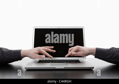 Deux mains tapant sur un clavier d'ordinateur portable, digital composite Banque D'Images