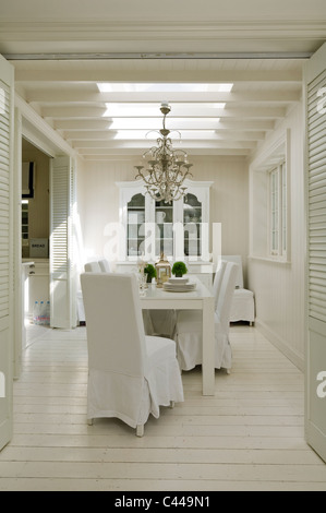 Salle à manger blanc avec puits, de parquet, d'une table et de chaises Banque D'Images