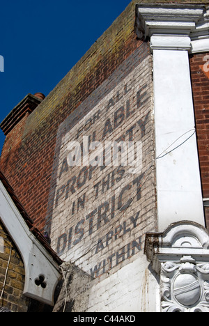 Un fantôme signe, ou la publicité, dans la rue qui n'Isleworth, ouest de Londres, en Angleterre, sur un bâtiment victorien Banque D'Images