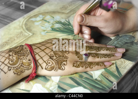 Artiste henné application du henné sur les mains de la femme de chambre de la mariée. Banque D'Images