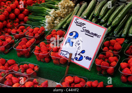 Fraises, Concombres, Oignons de printemps et les tomates sur une échoppe de marché à Cambridge, Cambridgeshire, Angleterre, RU Banque D'Images