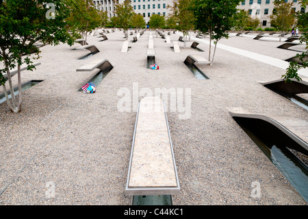 ARLINGTON, Virginie, États-Unis — le Mémorial du Pentagone est un hommage solennel aux 184 vies perdues lors de l'attaque du 11 septembre 2001 contre le Pentagone. Situé juste au sud-ouest du bâtiment du Pentagone, cet espace contemplatif comprend 184 unités commémoratives, chacune dédiée à une victime individuelle, disposées selon une chronologie de leurs âges. Le design, avec ses bancs en porte-à-faux et ses bassins réfléchissants, crée un environnement puissant pour le souvenir et la réflexion. Banque D'Images