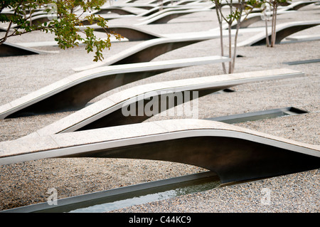 Bancs en porte-à-faux du Pentagone Memorial Arlington Virginie // ARLINGTON, Virginie, États-Unis — le Pentagone Memorial est un hommage solennel aux 184 vies perdues lors de l'attaque du 11 septembre 2001 contre le Pentagone. Situé juste au sud-ouest du bâtiment du Pentagone, cet espace contemplatif comprend 184 unités commémoratives, chacune dédiée à une victime individuelle, disposées selon une chronologie de leurs âges. Le design, avec ses bancs en porte-à-faux et ses bassins réfléchissants, crée un environnement puissant pour le souvenir et la réflexion. Banque D'Images