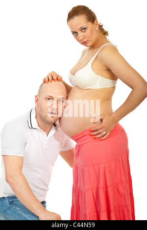 Futur père surpris à l'écoute de son bébé à naître isolé sur fond blanc Banque D'Images