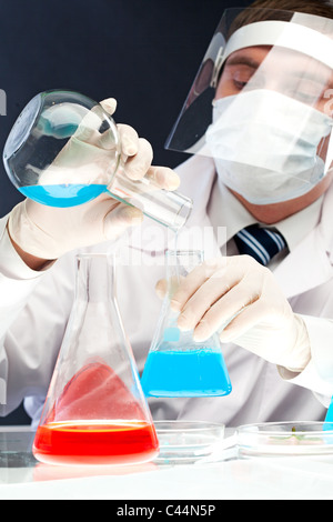 Droit de verser le liquide bleu clinicien dans le tube de verre in laboratory Banque D'Images