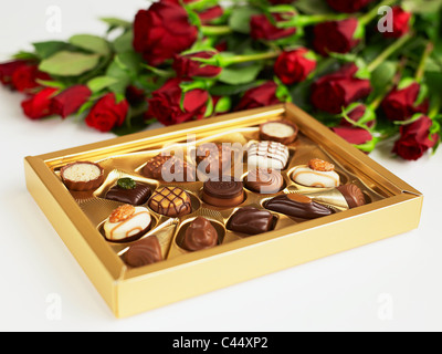 Boîte de chocolats et roses rouges, close-up Banque D'Images