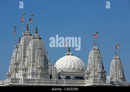 L'Angleterre, Londres, Temple BAPS Shri Swaminarayan Mandir, temple dome avec les drapeaux against sky Banque D'Images