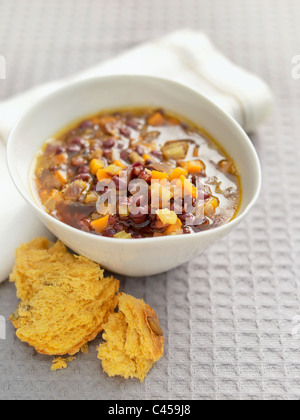 Bol de soupe de légumes Haricots adzuki servi avec pain, close-up Banque D'Images