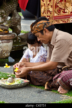 Père et fille faire puja à Pura Taman SARASWATI durant la fête GALUNGAN - UBUD, BALI, INDONÉSIE Banque D'Images