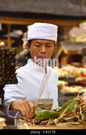 Un prêtre hindou offre de l'encens au TEMPLE TIRTA EMPUL PURA durant la fête GALUNGAN - TAMPAKSIRING, BALI, INDONÉSIE Banque D'Images