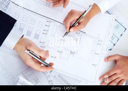Close-up of engineers mains avec plus de stylos bleus avec des croquis de projets Banque D'Images