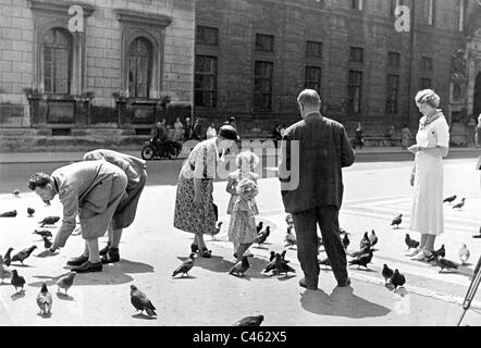 Nourrir les pigeons sur la Max-Joseph-Platz à Munich Banque D'Images