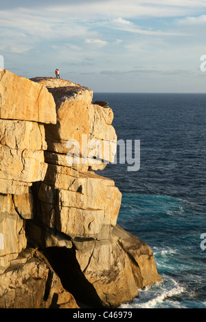 Couple debout sur clifftops à l'écart. Torndirrup National Park, Albany, Australie occidentale, Australie Banque D'Images