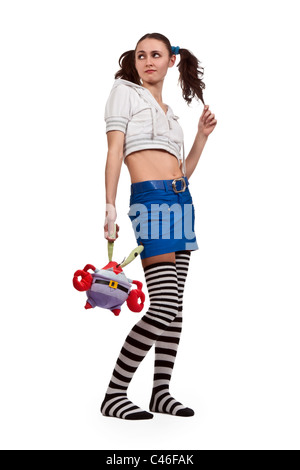 Fille en chaussettes rayées, mini jupe avec un jouet et de tresses Banque D'Images