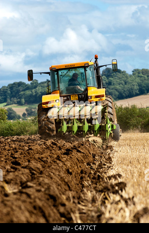 Tracteur Renault laboure un champ après la récolte est terminée Banque D'Images