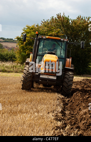 Tracteur Renault laboure un champ après la récolte est terminée Banque D'Images