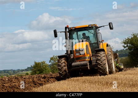 Tracteur Renault laboure un champ après la récolte est terminée Banque D'Images