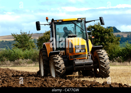 Tracteur Renault laboure un champ après la récolte est terminée Banque D'Images