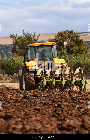 Tracteur Renault laboure un champ après la récolte est terminée Banque D'Images