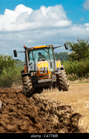 Tracteur Renault laboure un champ après la récolte est terminée Banque D'Images