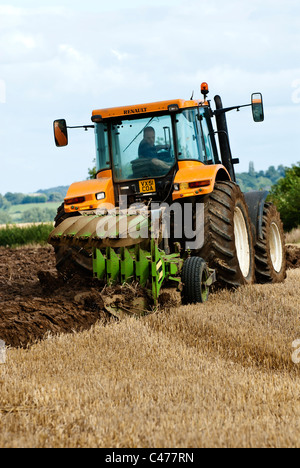 Tracteur Renault laboure un champ après la récolte est terminée Banque D'Images