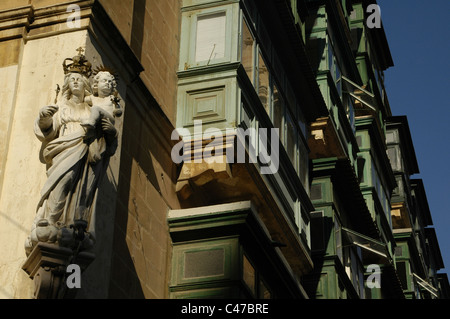 Une sculpture d'art sculpté à l'angle d'un immeuble résidentiel avec des balcons en bois typiques de la valette La capitale de l'île de Malte Banque D'Images